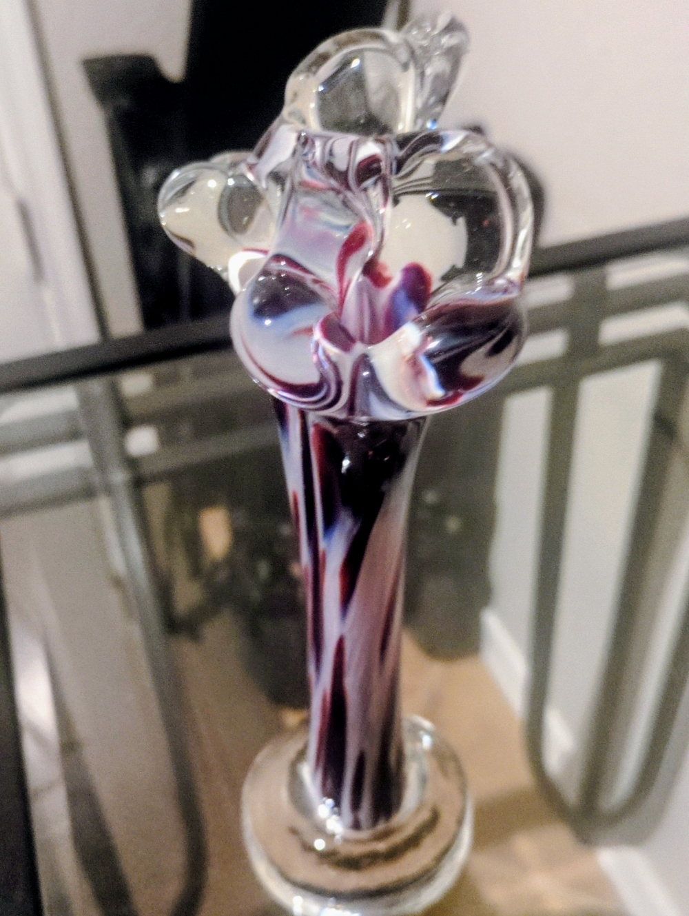 Vintage swirling art glass vase with a floral-shaped top.
